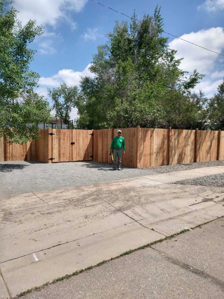 construction worker standing next to newly built fence