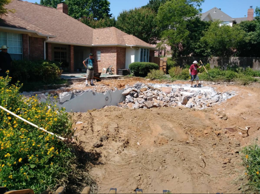 construction crew doing demo work in a backyard