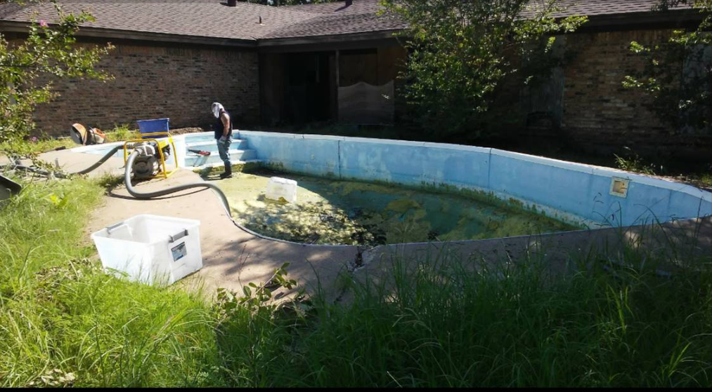 crew pumping water out of an old pool
