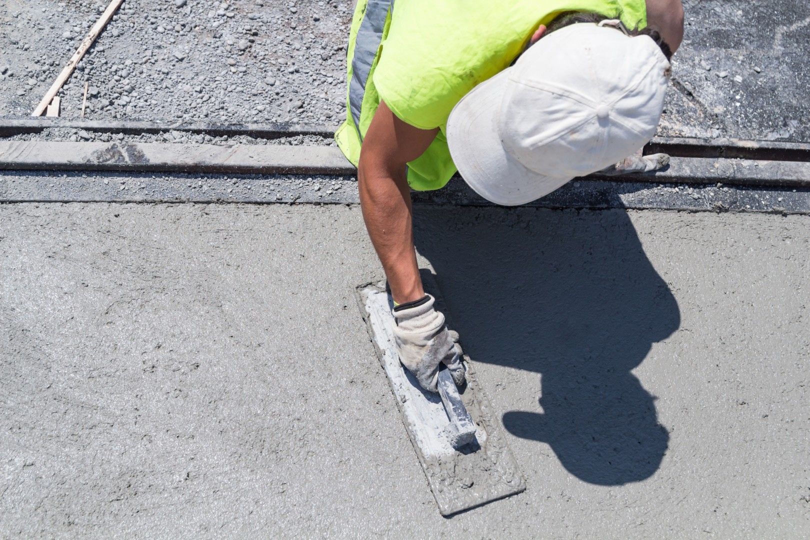 concrete worker smoothing out poured concrete